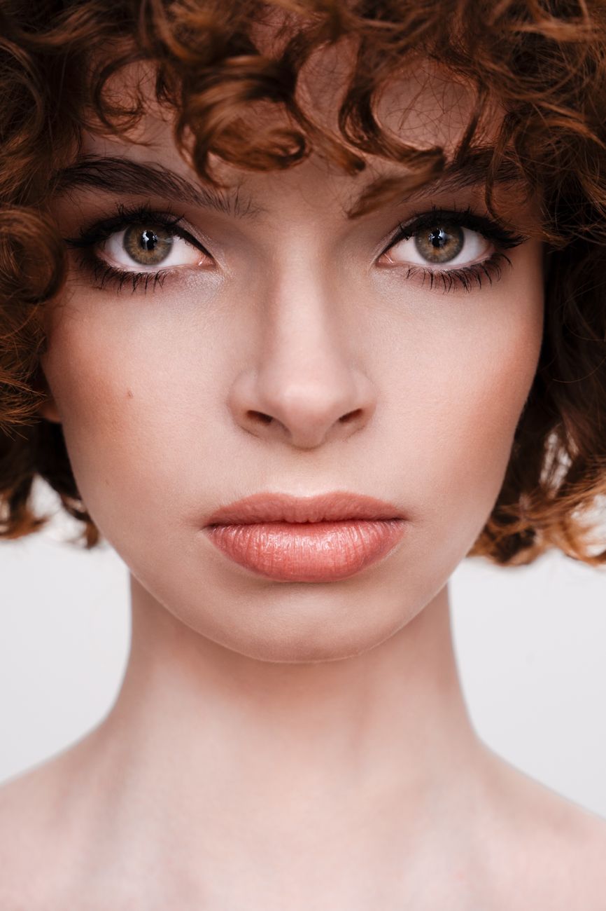 Beauty portrait of a model with curly auburn hair